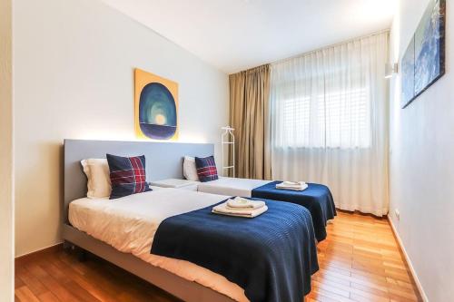 a bedroom with two beds and a window at Vita Portucale ! Expo Deluxe with Terrace in Lisbon