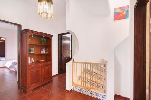 a hallway with a staircase and a wooden cabinet at Villa Luísa Galé in Albufeira