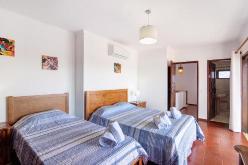 a bedroom with two beds and a hallway at Villa Luísa Galé in Albufeira
