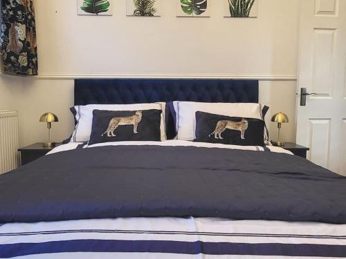 a bedroom with a blue bed with two pillows at Greystoke Mews in Woodborough