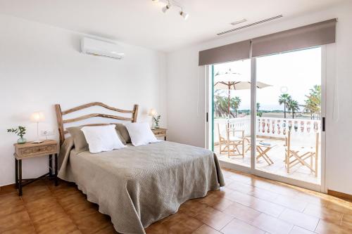 a bedroom with a bed and a view of a patio at Villa Dreams in Son Bou