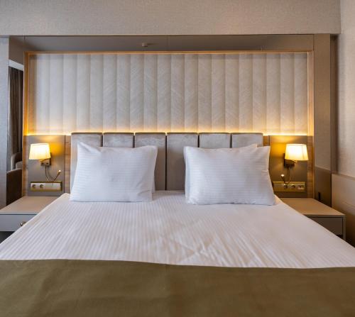 a bedroom with a large white bed with two pillows at Belenli Resort Hotel in Belek