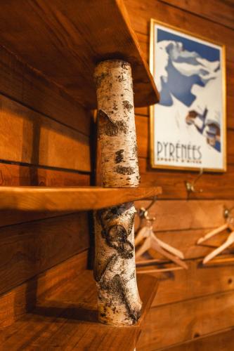 a wooden shelf with a sign on a wooden wall at Les Ruisseaux in Cauterets