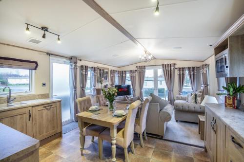 a kitchen and living room with a table and chairs at QUEEN V - Luxury Caravan - 2Bed - Seton Sands in Port Seton