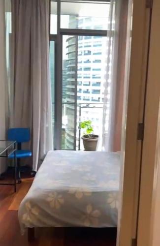 a bed in a room with a large window at Avenue K in Kuala Lumpur