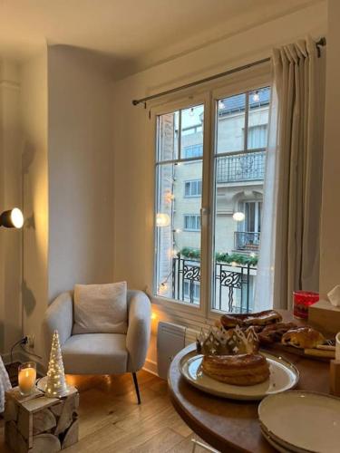 - un salon avec une table, une chaise et une fenêtre dans l'établissement Louis’ haven, à Paris