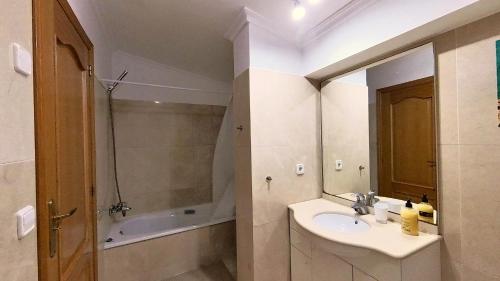 a bathroom with a sink and a mirror and a tub at BiBi House in Jávea