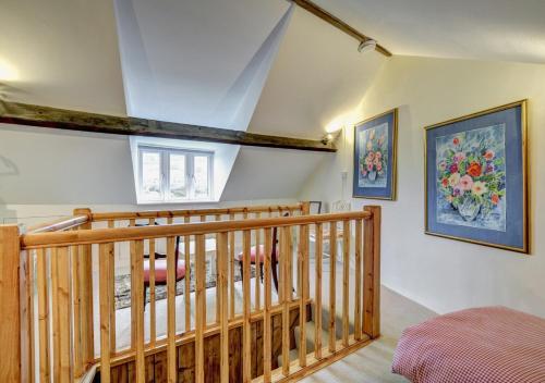 a room with a wooden staircase and a window at Meadow Cottage in Bridport