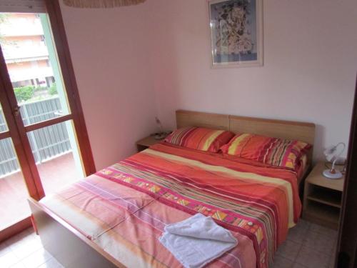 um quarto com uma cama com um cobertor colorido em Relax and chill by the pool - Beahost em Bibione