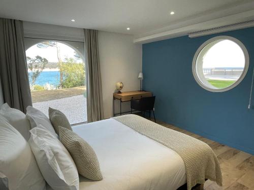 une chambre avec un grand lit et deux fenêtres dans l'établissement Maison de Maître avec piscine en front de mer, à La Seyne-sur-Mer