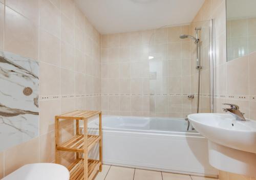 a bathroom with a tub and a sink and a toilet at Flat 9 Broadleys in Swanage