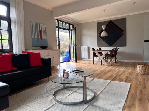 a living room with a black couch and a table at FeWo Schöne Aussicht in Plettenberg