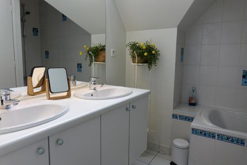 a white bathroom with two sinks and a mirror at La Maison de Saint-Dyé in Saint-Dyé-sur-Loire