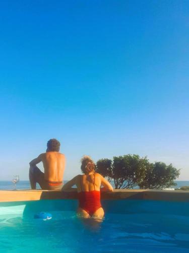 two people in the water in a swimming pool at Caldeira Guesthouse in Fajã da Caldeira de Santo Cristo