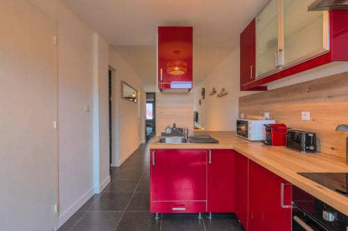 - une cuisine avec des placards rouges et un évier rouge dans l'établissement 3 bedroom house with terrace, near Lille, à Marcq-en-Barœul