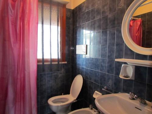 uma casa de banho com um WC, um lavatório e um espelho. em Relax and chill by the pool - Beahost em Bibione