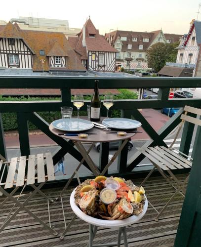 - une table avec une assiette de nourriture et une bouteille de vin dans l'établissement Les Mouettes à Deauville, à Deauville