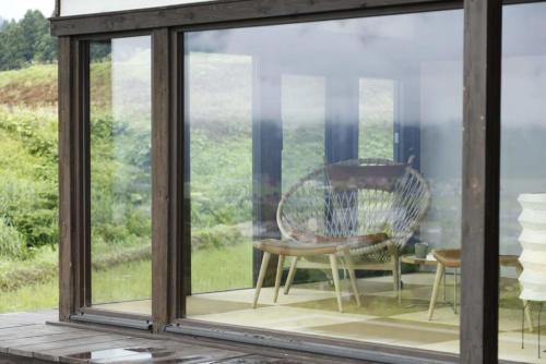 a screened in porch with a table and a chair at Satoyama Jujo in Minami Uonuma