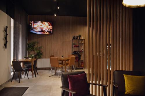 um restaurante com mesa e cadeiras e uma televisão na parede em Laurentroom Hotel em Ukmergė