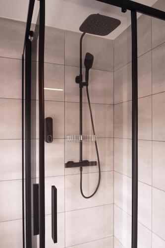 eine Dusche mit Duschkopf in einem Badezimmer in der Unterkunft Laurentroom Hotel in Ukmergė