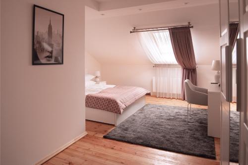 a bedroom with a bed and a rug at Laurentroom Hotel in Ukmergė