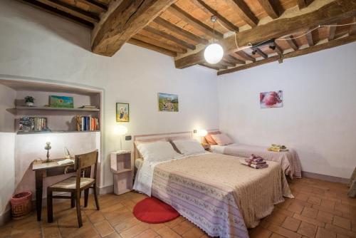 a bedroom with a bed and a desk in a room at La Casa Gialla di Buonconvento in Buonconvento