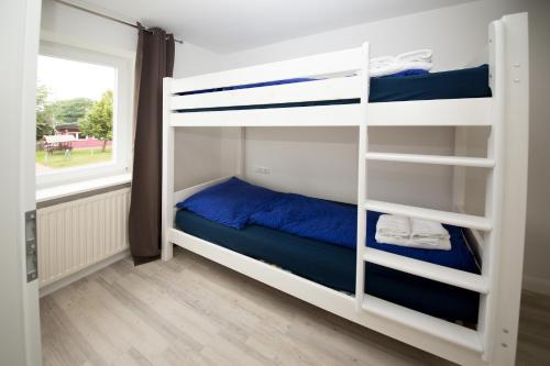 a bedroom with bunk beds and a window at Schleiblick App 19 in Rabenkirchen-Faulück