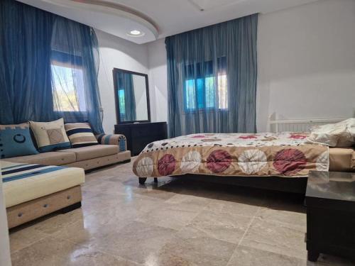 トリッファにあるVilla Dejerba Midounのベッドとソファのある寝室