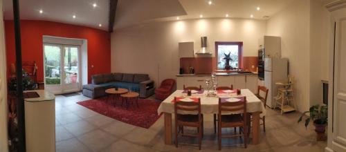 uma cozinha e uma sala de estar com mesa e cadeiras em La Grillère em Conliège