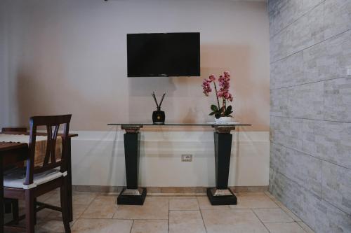 a room with a table and a tv on a wall at Civico 9 in Brindisi