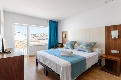 a bedroom with a bed and a balcony at Hostal Neptuno in Paguera