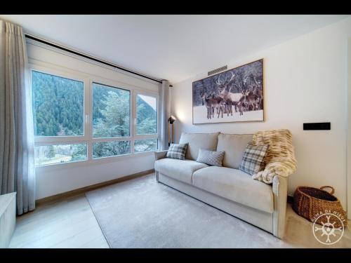 a living room with a couch and a large window at SHIVAU de Alma de Nieve in Baqueira-Beret