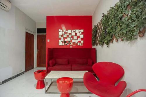 - un salon avec un canapé rouge et des fauteuils rouges dans l'établissement Mega Stay near Mall Kelapa Gading, à Jakarta