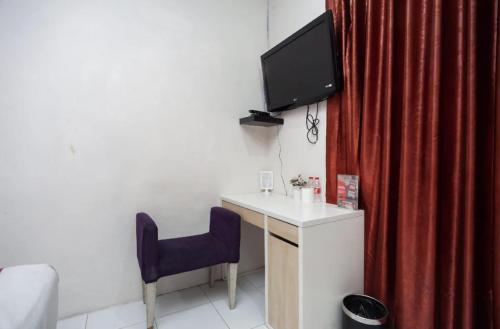 a room with a desk and a tv on the wall at Mega Stay near Mall Kelapa Gading in Jakarta