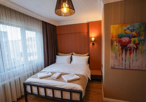 a bedroom with a bed with a painting on the wall at THE BEYBÛN HOTEL in Istanbul