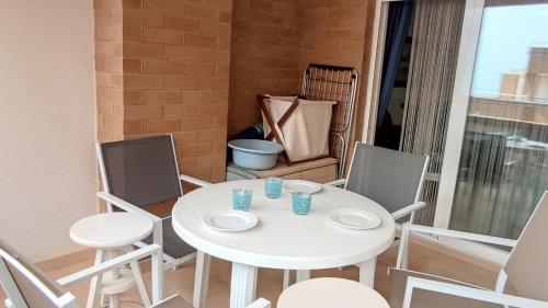 een witte tafel en stoelen op een balkon bij ACV- Costa Marina I-1ªlinea planta 5 norte in Oropesa del Mar