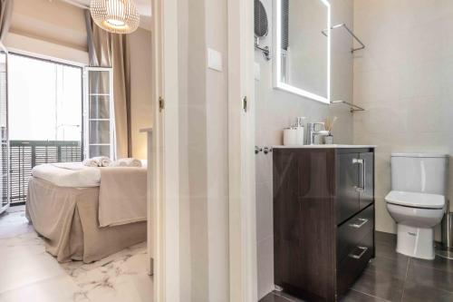 ein Bad mit einem Waschbecken, einem WC und einem Bett in der Unterkunft Central & authentic apartment with balcony by REMS in Málaga