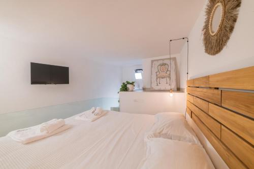 a white bedroom with a bed and a tv at Fjore di Lecce, camere & caffè in Lecce