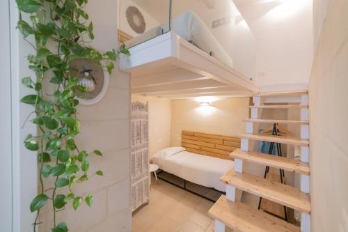 a small room with a bed and a staircase at Fjore di Lecce, camere & caffè in Lecce