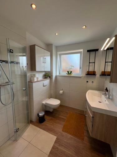 a bathroom with a toilet and a sink and a shower at Ferienwohnung Aspelohe - Apartment 2 in Norderstedt