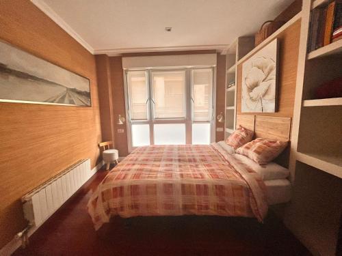 a bedroom with a bed and a large window at Ideal Parejas in Lekeitio