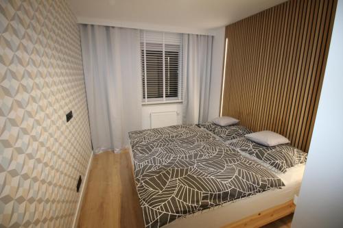 Apartament ARS Platinium Wisła في فيسلا: غرفة نوم بسرير ونافذة