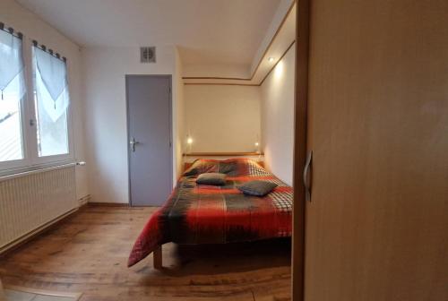 a bedroom with a bed with a red blanket at Chalet les Moineaux Chambres d'Hôtes in Jausiers