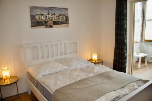 a bed in a bedroom with two lamps on tables at Strandvogtei Sellin - FeWo 5 - sehr zentrales großes Apartment in Ostseebad Sellin