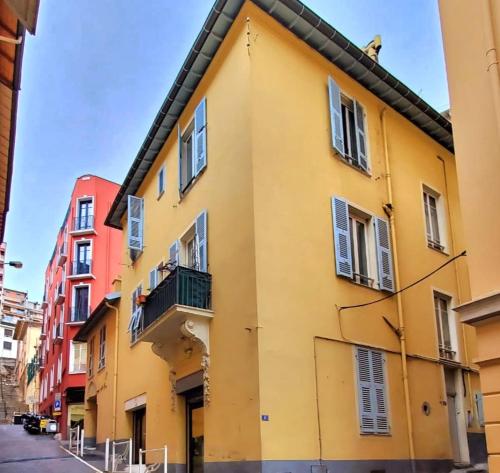 a yellow building with windows and a balcony at Studio Mezzanine neuf, Monaco à pied, Clim - WIFI in Beausoleil