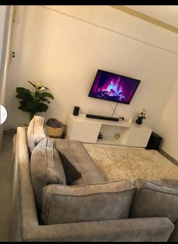 sala de estar con sofá y TV de pantalla plana en Vanquish luxury, en Nairobi