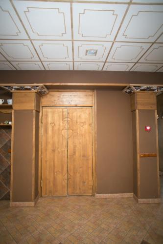 a large wooden door in a room with a ceiling at Tulipan Hotel Aquapark in Vyshkove