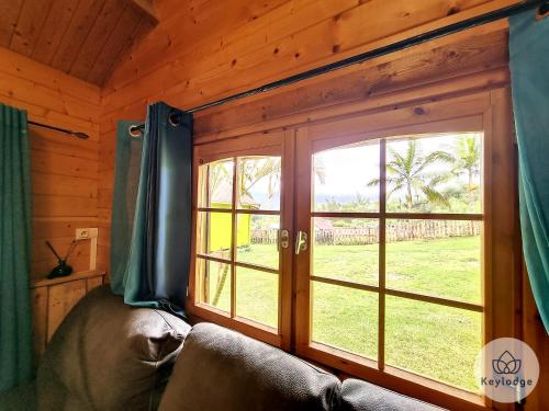 ein Wohnzimmer mit einem großen Fenster in einer Hütte in der Unterkunft Joli Coeur - Bungalow aux Makes - Saint-Louis in Saint-Louis