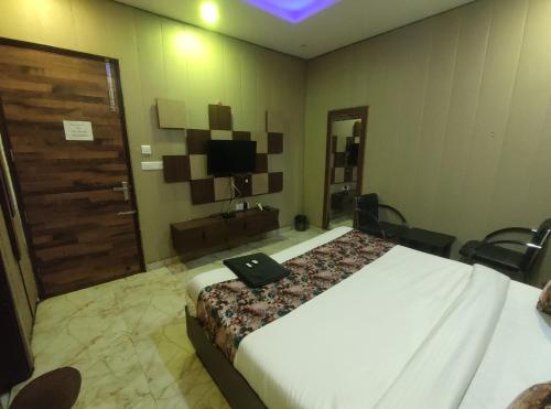 a hotel room with a bed and a television at Hotel Pearl Grand Prime in Karnal