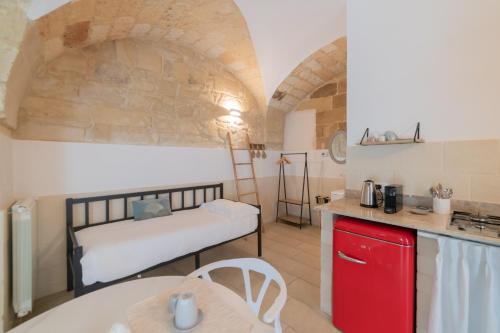 a room with a bed and a kitchen with a table at Fjore di Lecce, camere & caffè in Lecce